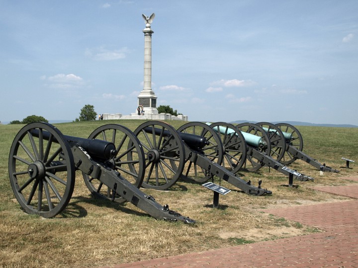A Line of Union and Confederate Cannons With the New York State Monument in the Background A Line of Union and Confederate Cannons With the New York State Monument in the Background